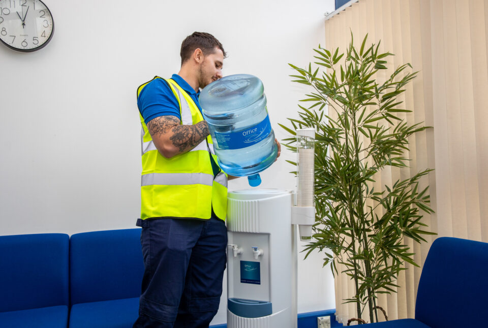 Engineer installing a water bottle onto a cooler